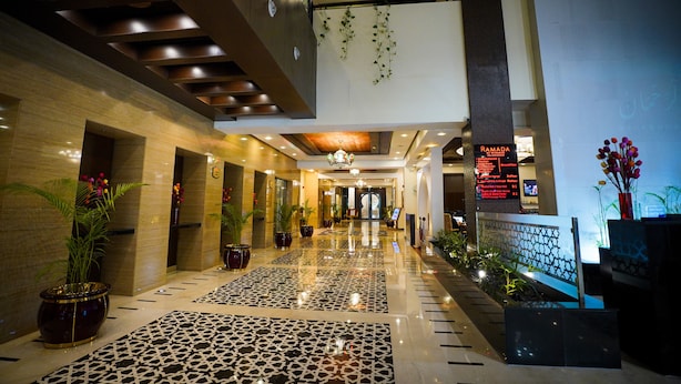 A spacious hotel lobby with a high ceiling, modern lighting, and a central chandelier. - Ramada by Wyndham Islamabad (Islamabad)