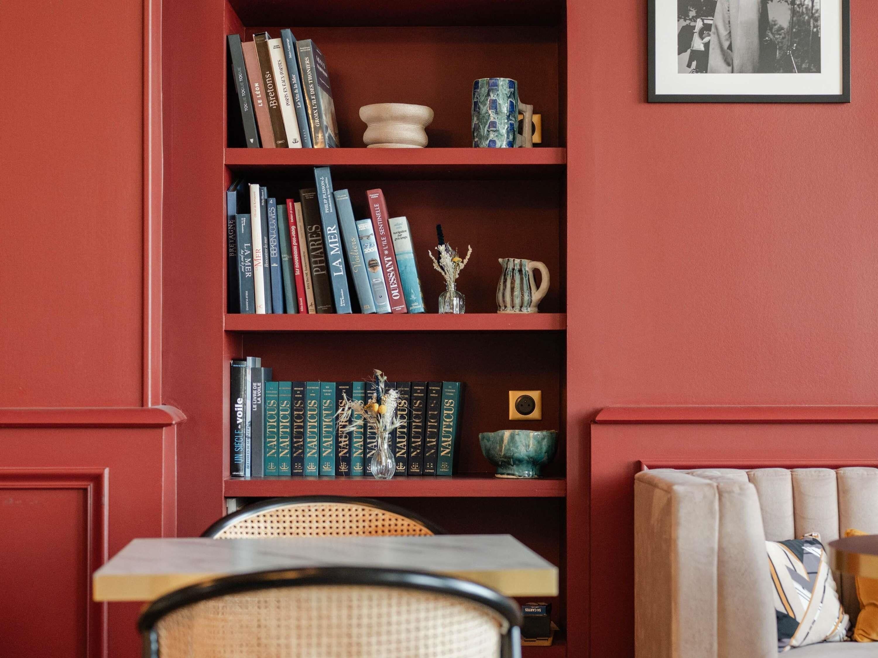 A bookshelf with books, a vase, and a mug.
