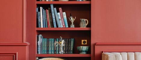 A bookshelf with books, a vase, and a mug.