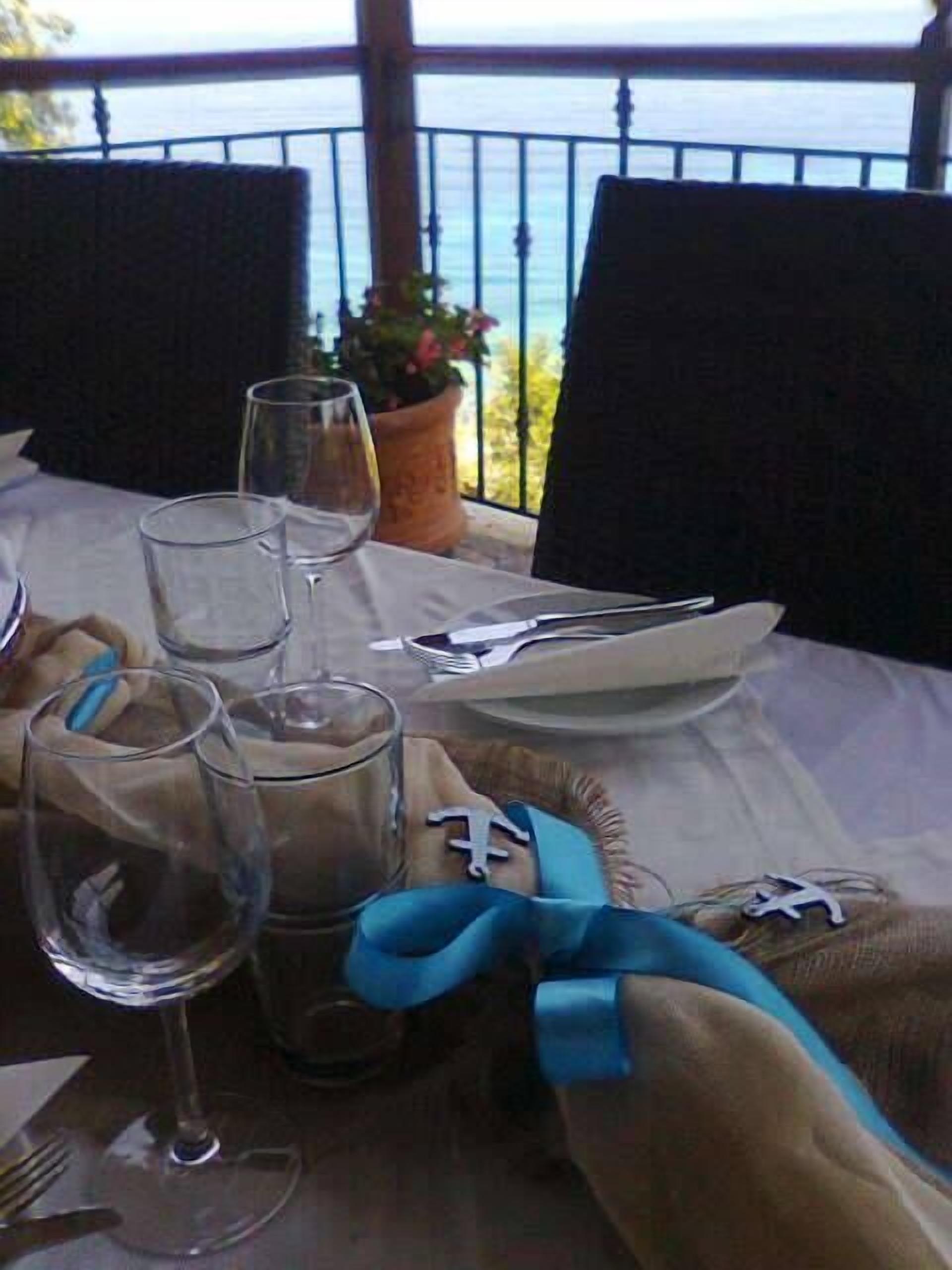 A table set for two with wine glasses, a plate, and cutlery.