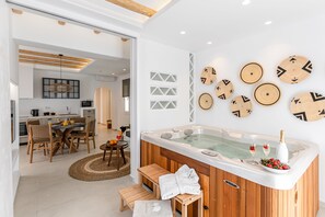 A modern bathroom with a wooden bathtub, a vanity, and a shower area. - Sea & Olives Holiday Villas and Suites (Naxos)