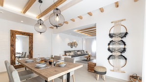 Un comedor amplio con una mesa de madera, sillas tapizadas en gris y un espejo grande.