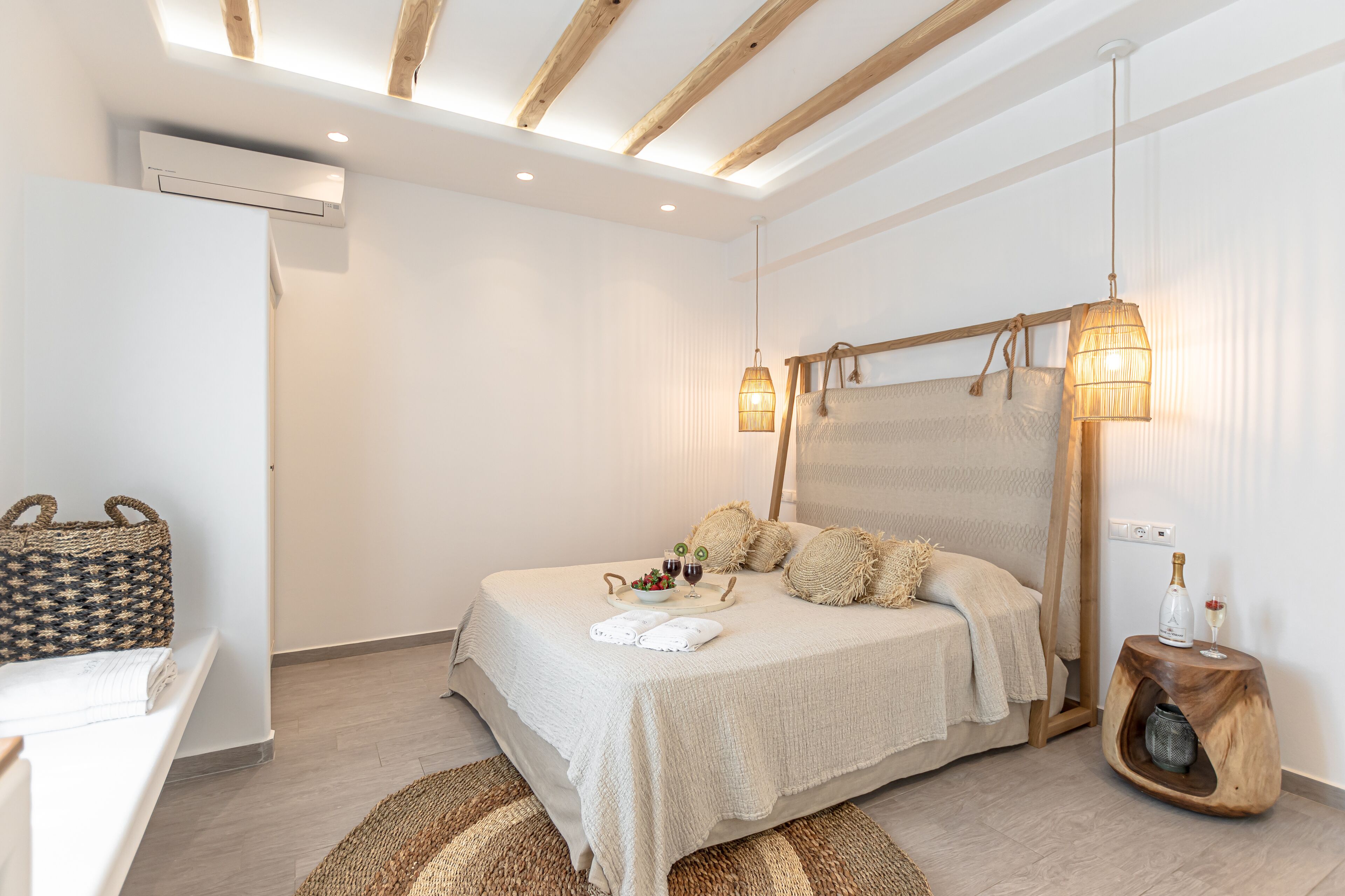Ein Schlafzimmer mit Bett, Nachttisch, Lampe und einer Pendelleuchte.