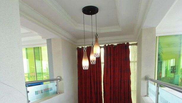 Un pasillo con cortinas rojas, un letrero que dice 'ROYAL PALACE' y una barandilla.