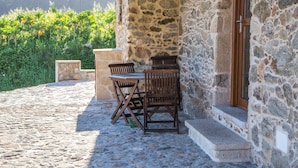 Un edificio de piedra con una escalera de piedra que lleva a una puerta de madera.