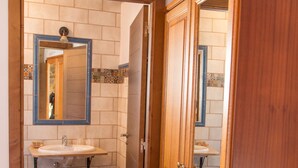 Un baño con tocador de madera, dos lavamanos y un espejo.