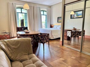 A hotel room with a bed, a dining table, a sofa, and a chair. - Atrium Quinta De Pedras (Belem)