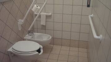 Un bany estàndard amb vàter, bidet i barana de suport.