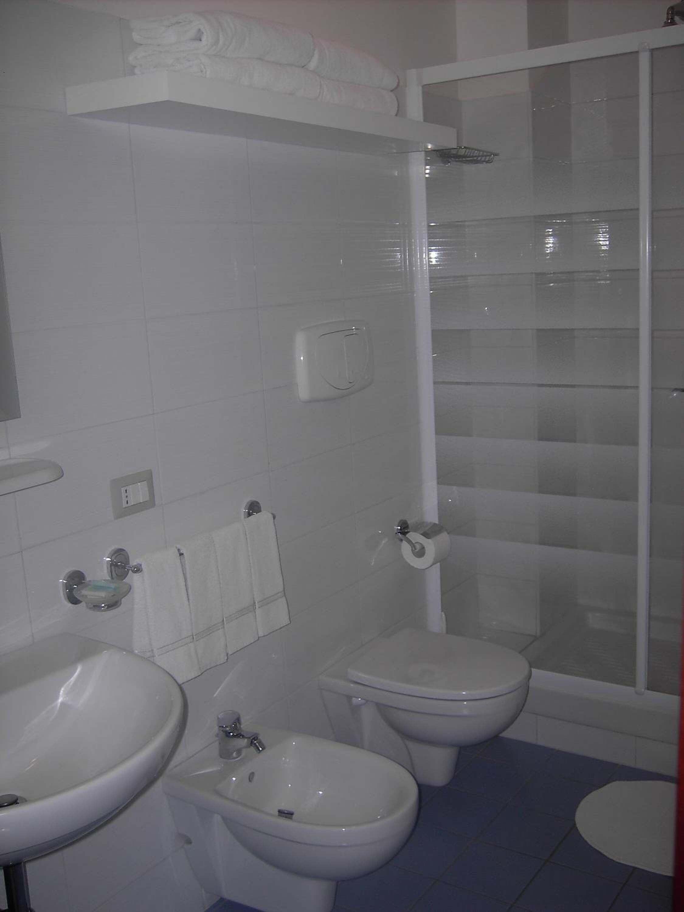 A bathroom with a toilet, bidet, and sink.