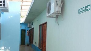 Ein Korridor mit blauer und weißer Wand, einem Schild, das einen Ausgang weist, und einer an der Wand befestigten Klimaanlage.