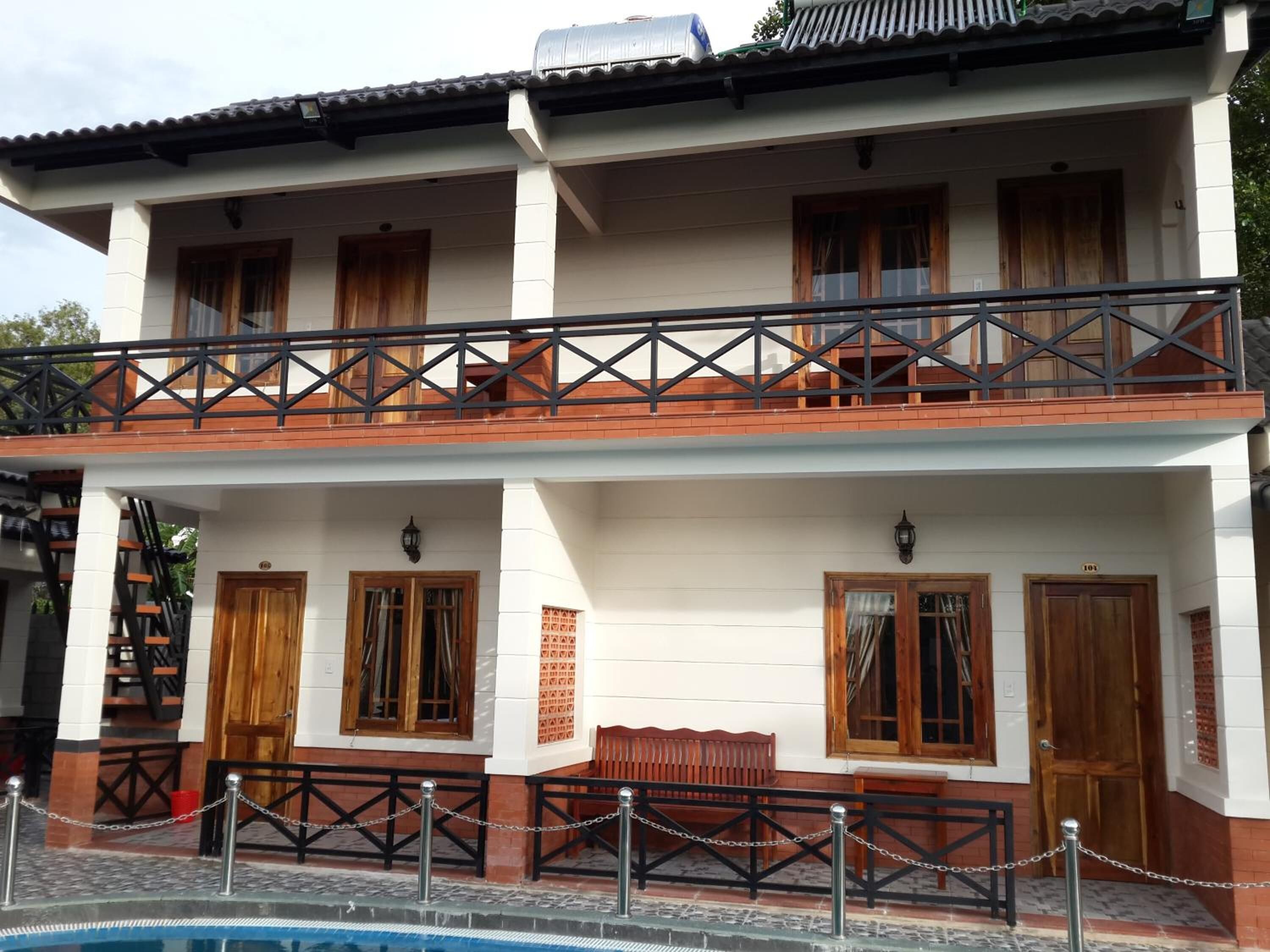 A two-story building with a balcony, wooden doors, and a chain-locked entrance.