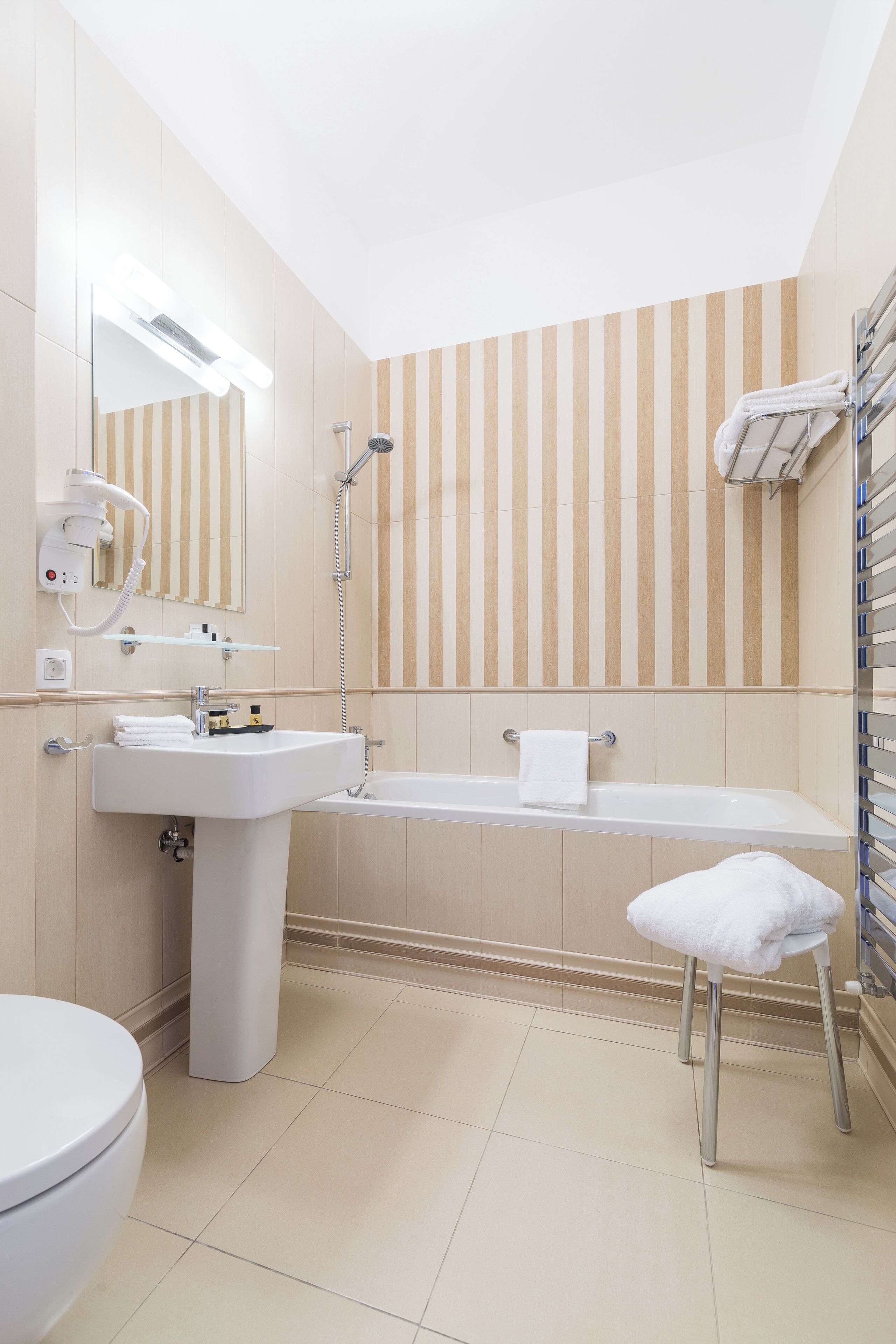 A modern bathroom with a white sink, a bathtub, a toilet, and a shower.
