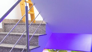 Eine Treppe mit Metallgeländern, einem Heizkörper und einer Wand mit blumigem Tapetenmuster.
