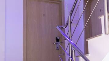 A modern interior with a wooden door, metal handrail, and a light strip above the door.