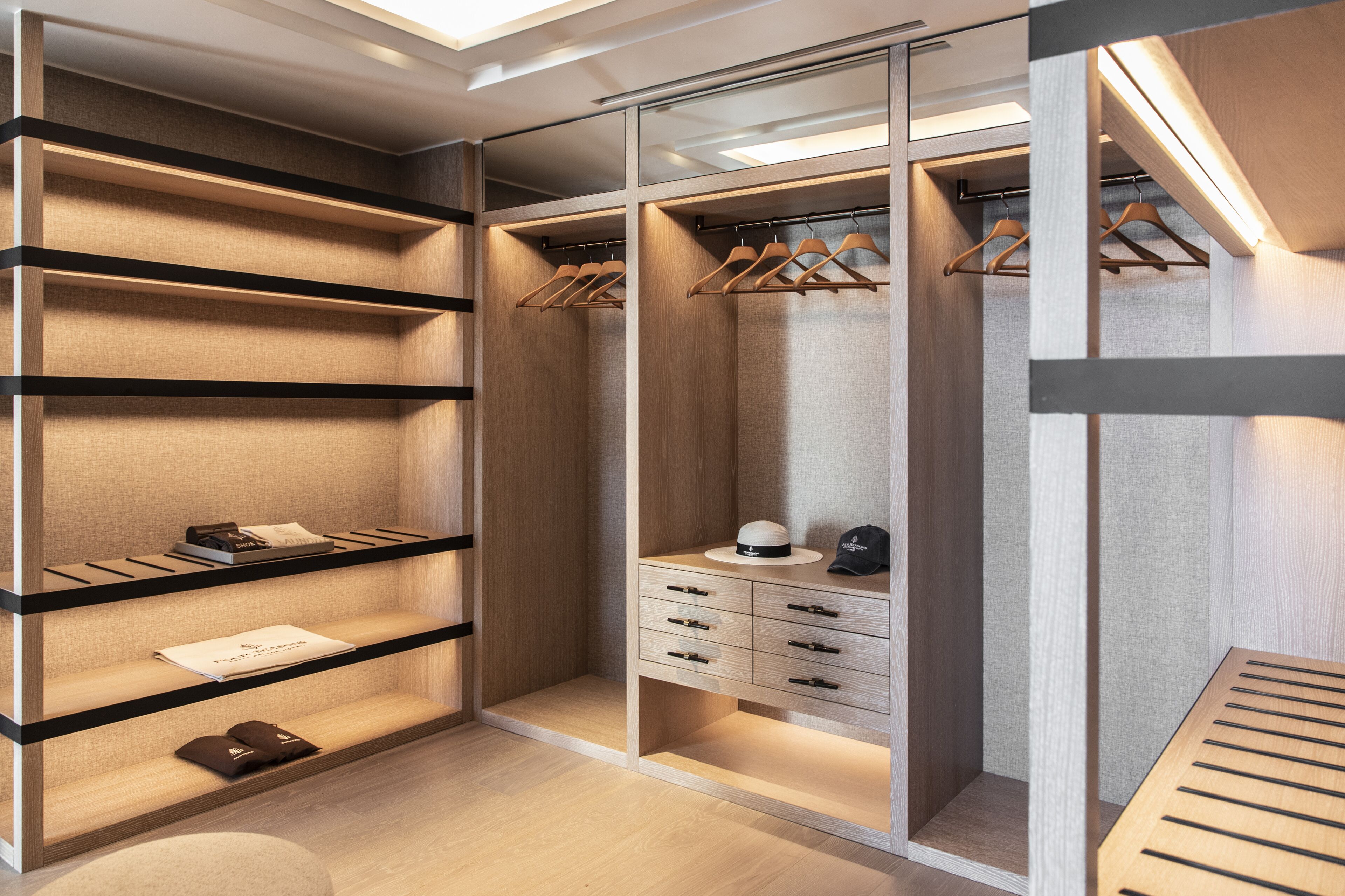 A walk-in closet with open shelves, hanging space, and drawers.