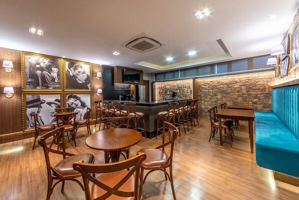 A restaurant with wooden furniture, a bar area, and a stone wall. - Langhetto Siena (Gramado)
