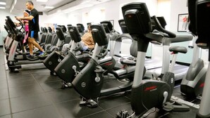 Une salle de sport équipée de plusieurs vélos d’exercice et de tapis de course.