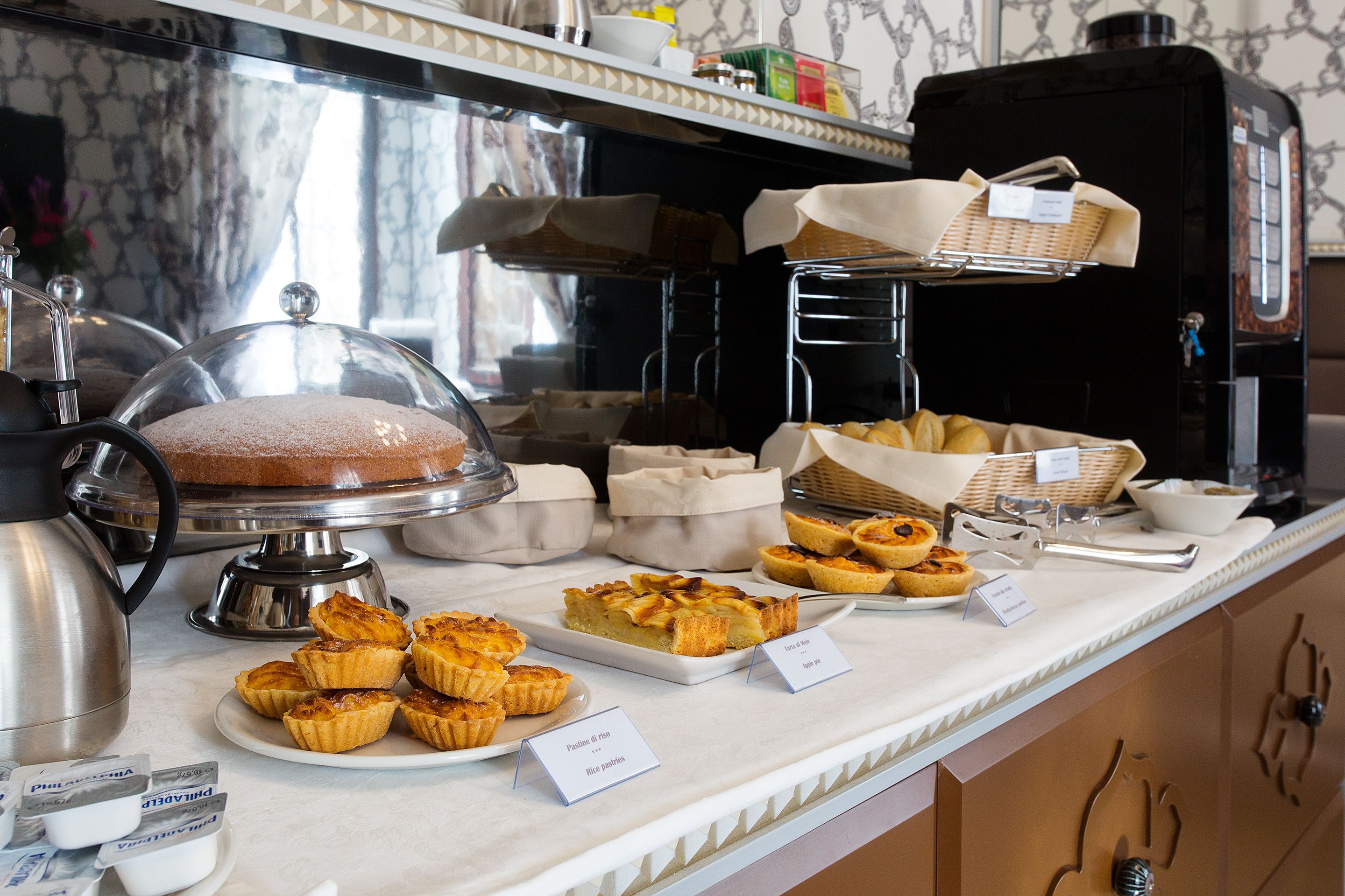 A buffet with various baked goods and a coffee machine.