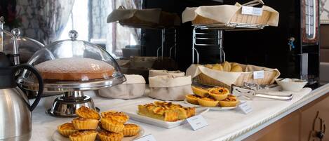 A buffet with various baked goods and a coffee machine.