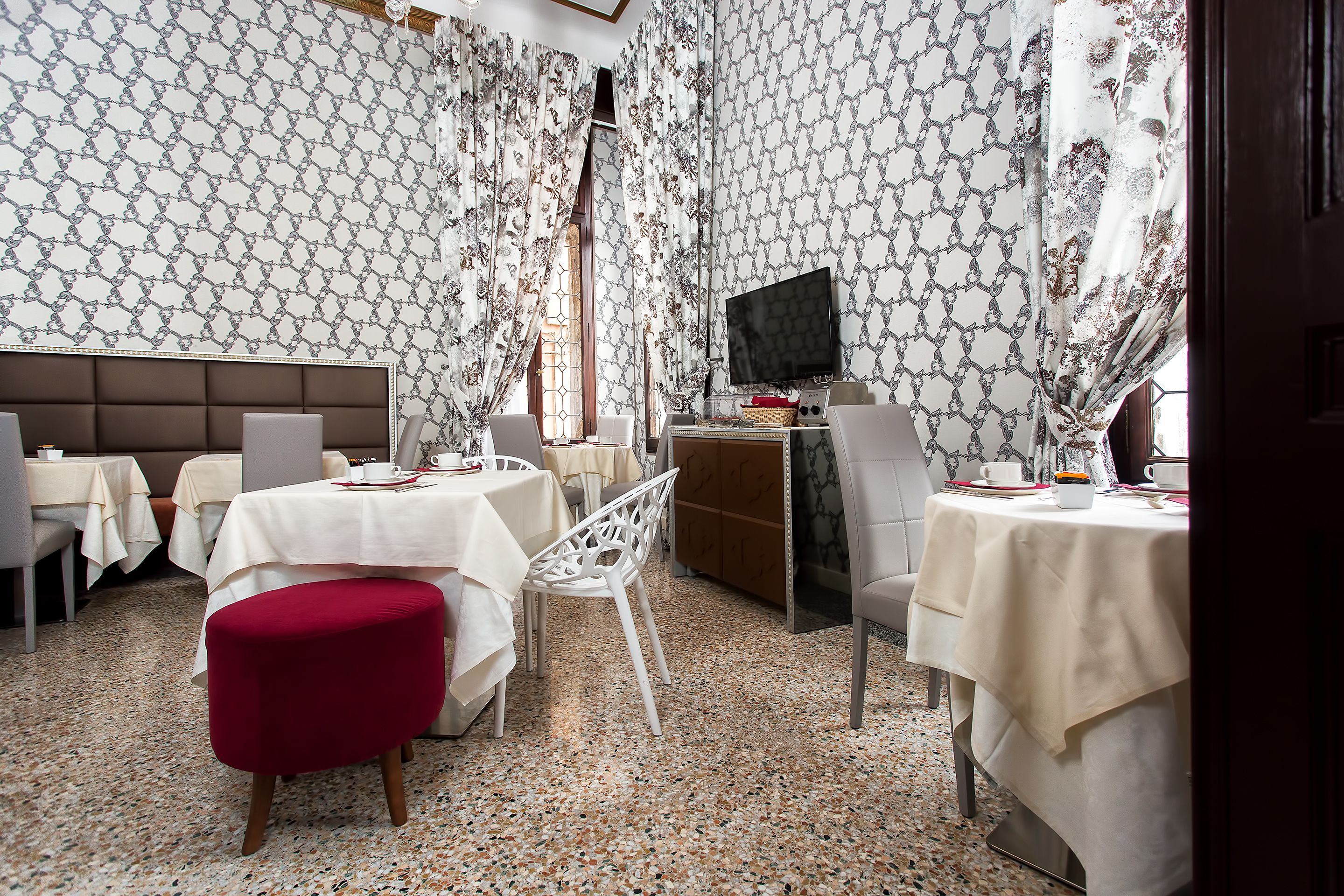 Comedor con varias mesas, sillas y televisor.