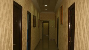 A hallway with patterned walls and doors, leading to a room. - Esado Suites and Conference Oregun (Lagos)