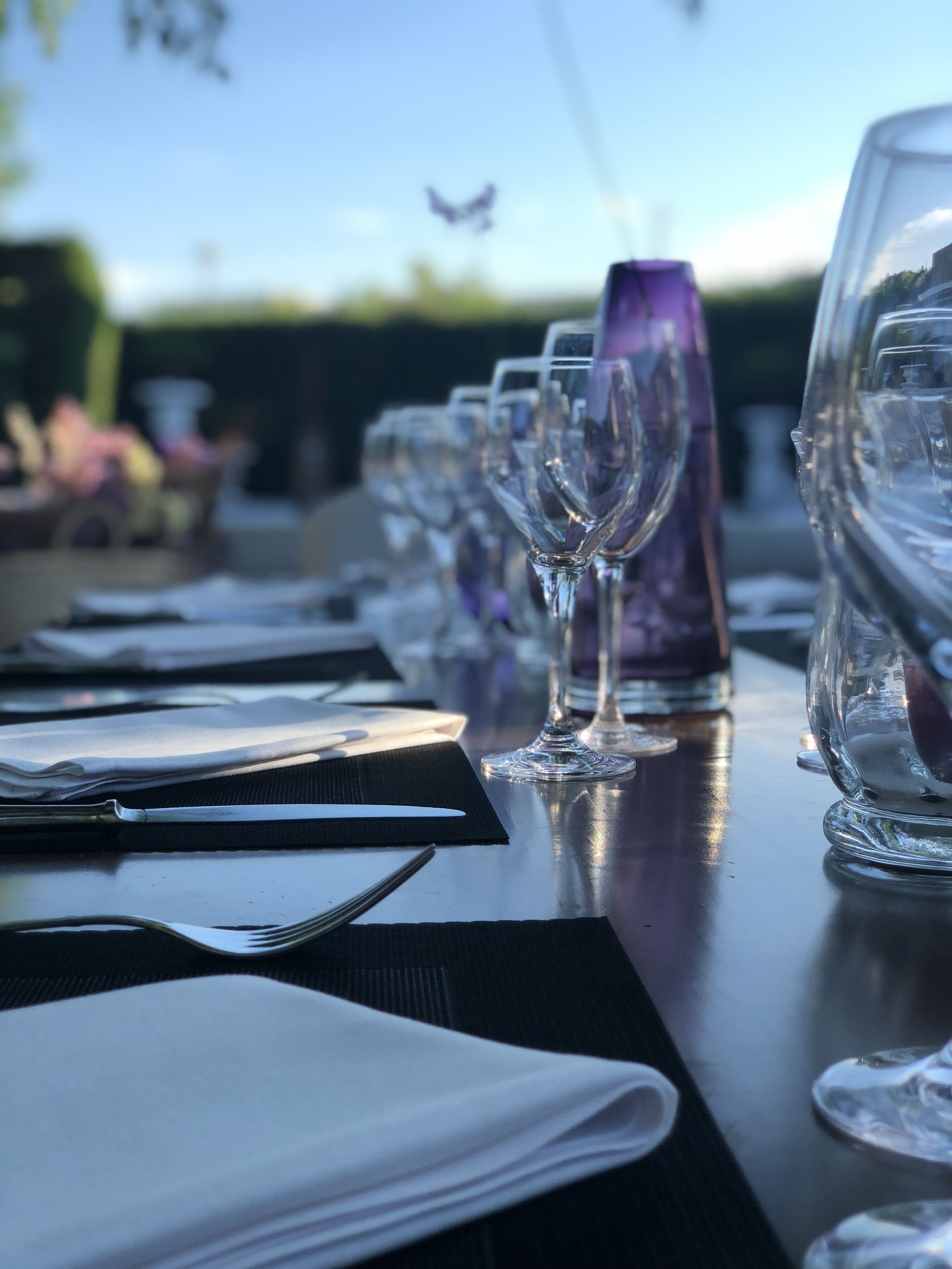 A table set for a meal with wine glasses, a bottle, and cutlery.