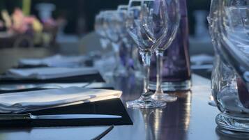 Une table mise pour un repas, avec des verres à vin, une bouteille et des couverts.