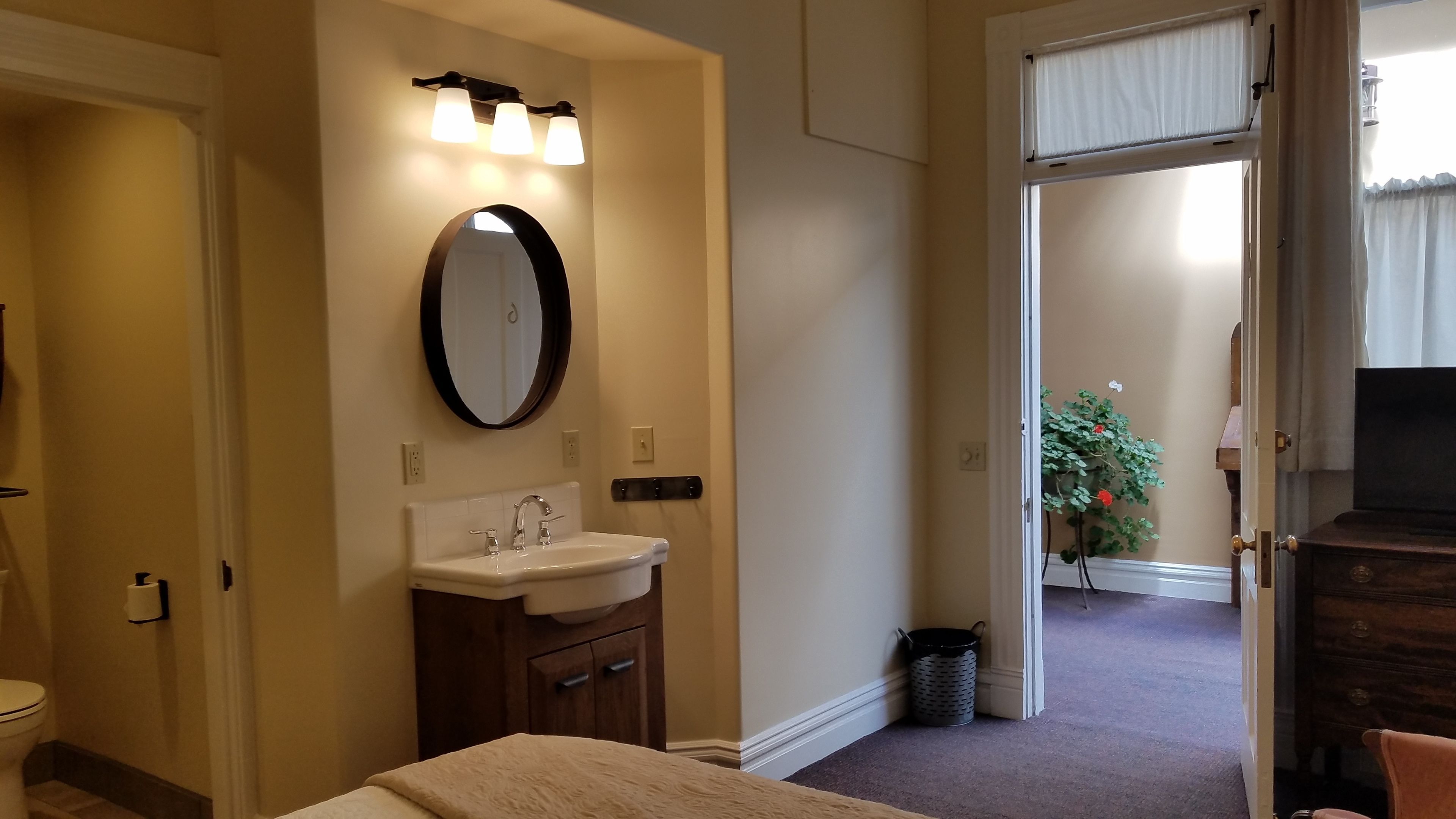 A hotel bathroom with a sink, mirror, and toilet.