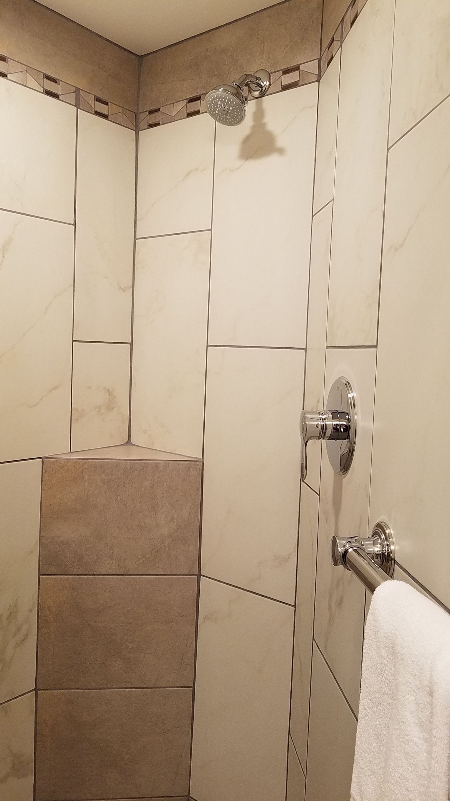 A shower area with beige tiles and a showerhead.