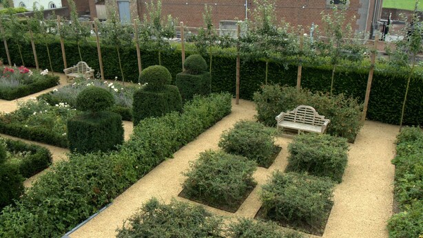 A well-maintained garden with neatly trimmed hedges and a gravel path. - Hotel Vorsen (Gingelom)