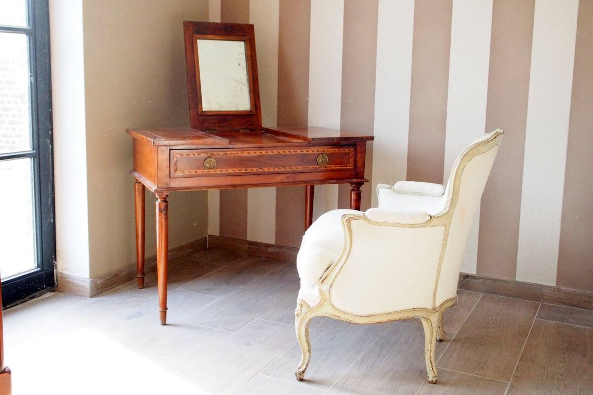 Une pièce avec un bureau en bois, une chaise et un miroir.