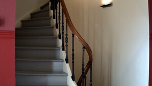 A staircase with wooden balusters and a handrail, leading to a landing with a light fixture. - Hotel Vorsen (Gingelom)