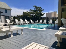 Una piscina al aire libre de temporada, sillones reclinables de piscina