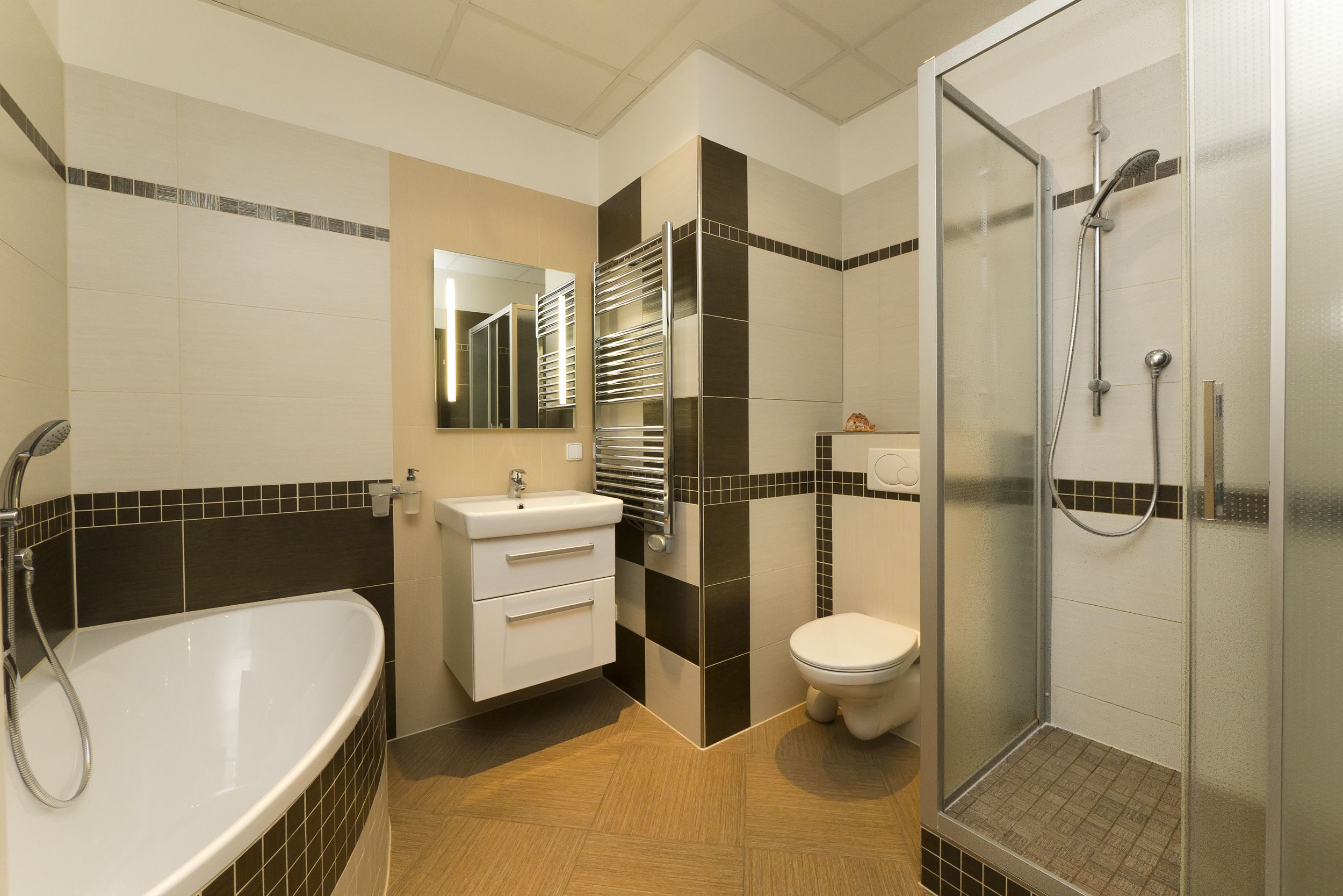 A modern bathroom with a bathtub, toilet, and shower.