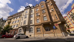 Un immeuble à étages doté d’un style architectural classique, caractérisé par des fenêtres en arc et une façade en pierre.