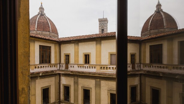 A courtyard with a domed building and a bell tower. - The Artists' Palace Florence (Florence)