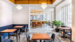 Um interior moderno com área de bar, assentos e grandes janelas.