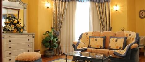 A living room with a sofa, ottoman, coffee table, and a large mirror.