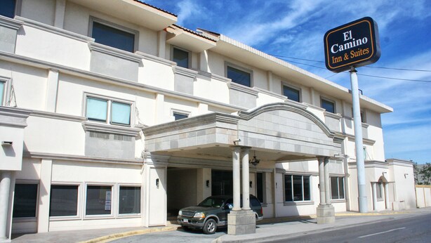 A hotel with a covered entrance, multiple windows, and a sign indicating it is El Camino Inn & Suites. - Hotel El Camino Inn & Suites (Reynosa)