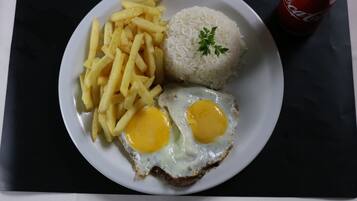 A plate with French fries, white rice, and fried eggs.