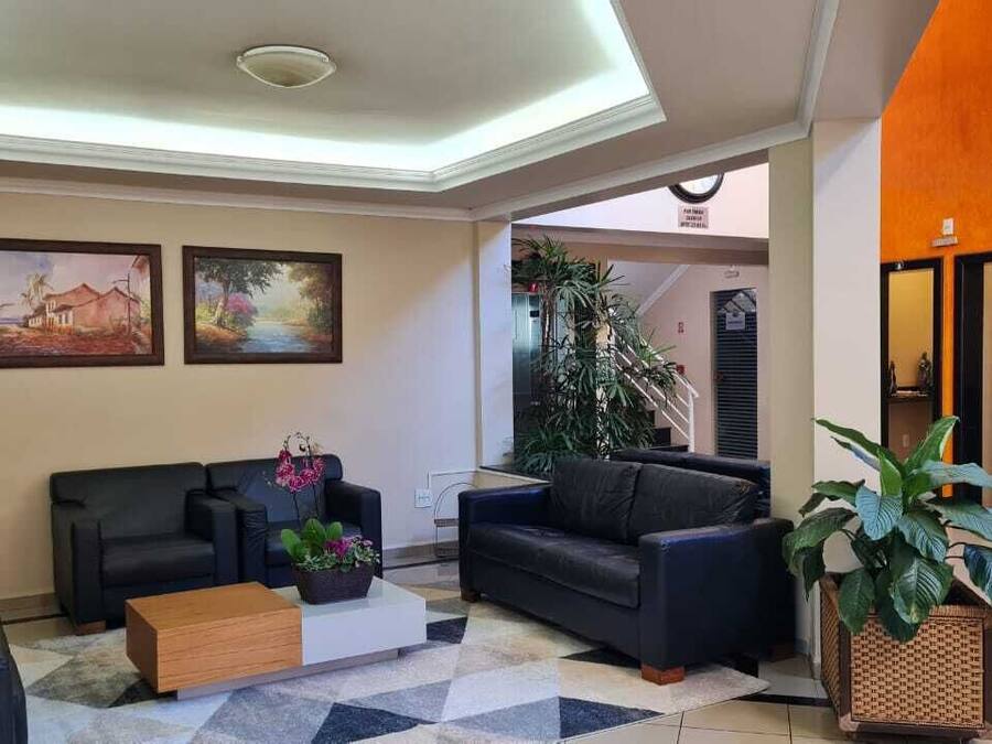 A modern lobby with two sofas, a coffee table, and potted plants.