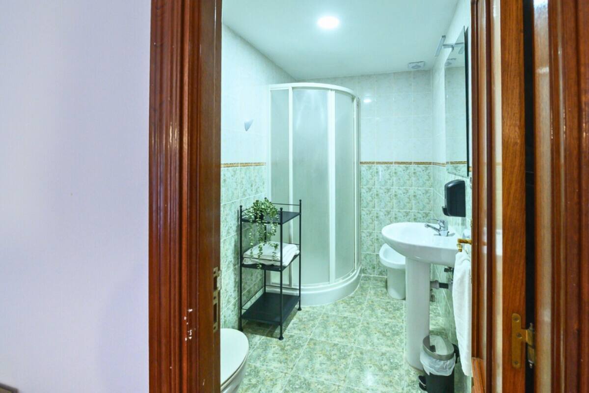 A bathroom with a toilet, sink, and shower.
