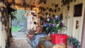 Un intérieur chaleureux avec un banc en bois, une poubelle de recyclage rouge et divers objets décoratifs accrochés aux murs.