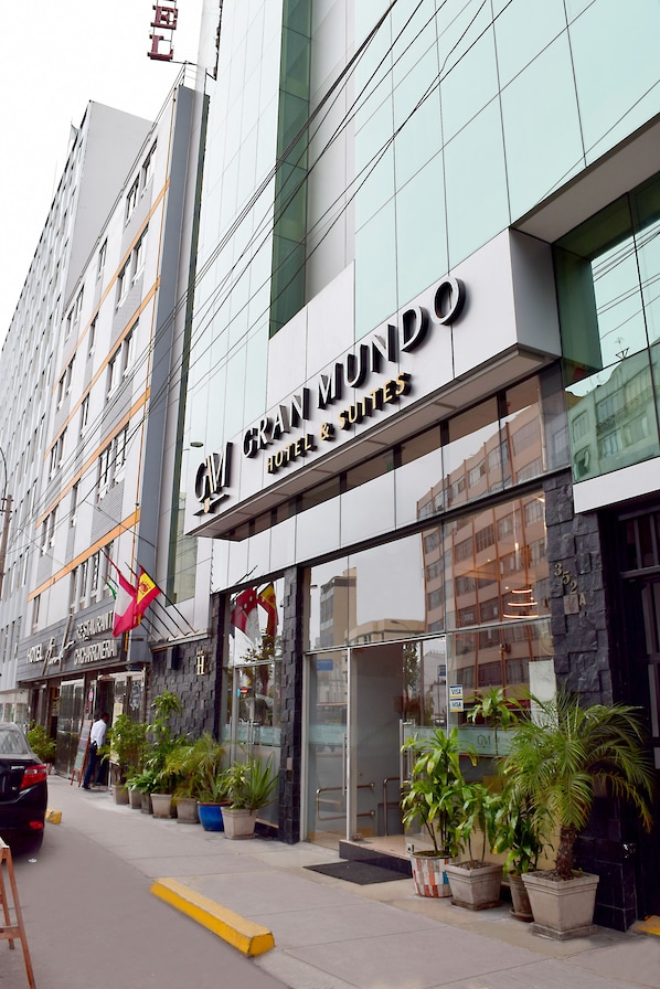 A hotel with a modern facade, large windows, and a sign for 'Gran Mundo Hotel & Suites'. - Gran Mundo Hotel (Lima)