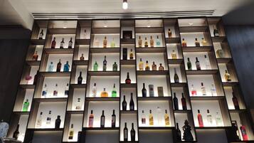 Un mur rempli d’étagères où sont exposées différentes bouteilles d’alcool, probablement dans un bar ou un magasin de boissons alcoolisées.