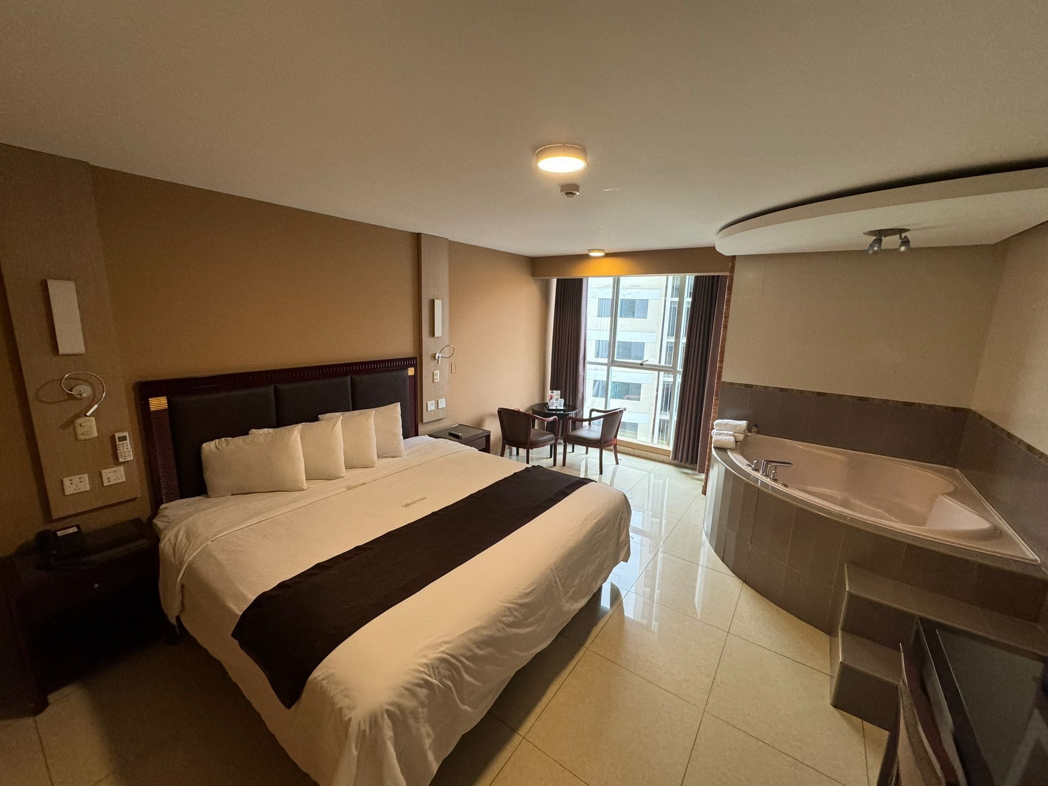 Una habitación de hotel con una cama grande, un escritorio y un baño.