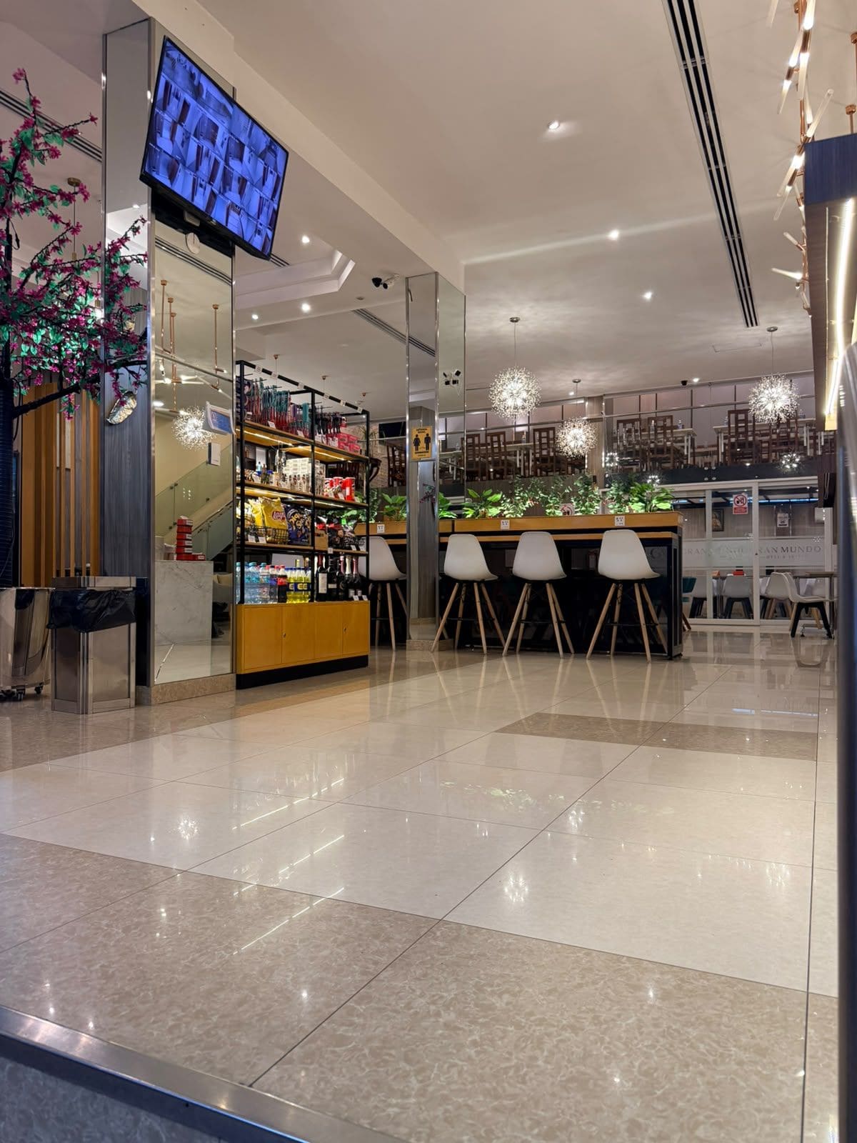 A modern interior with a digital display, a bar area, and seating.