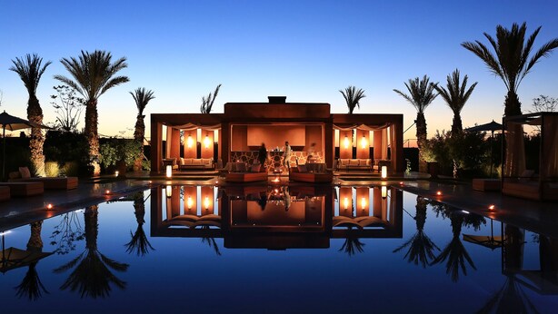 A luxurious poolside area with a reflective pool, outdoor seating, and ambient lighting. - Dar Sofil - Adults Only (Marrakech)