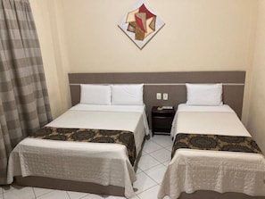 A hotel room with two beds, a nightstand, and a wall art piece.