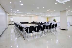 A conference room with a long table and chairs, a whiteboard, and a small plant. - Hotel Domani (Guarulhos)